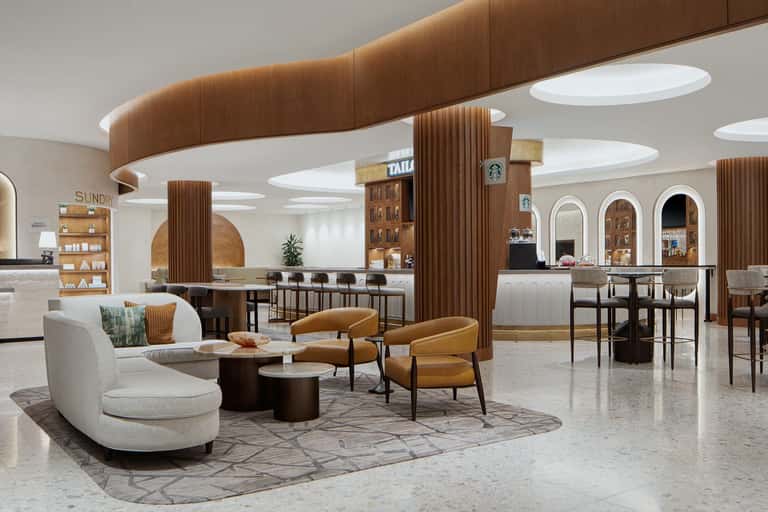 Modern hotel lobby with curved seating, wood-paneled columns, and contemporary design