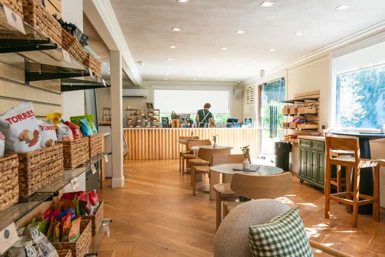 Bright spa café or wellness center with wooden counter, snack display, and natural light