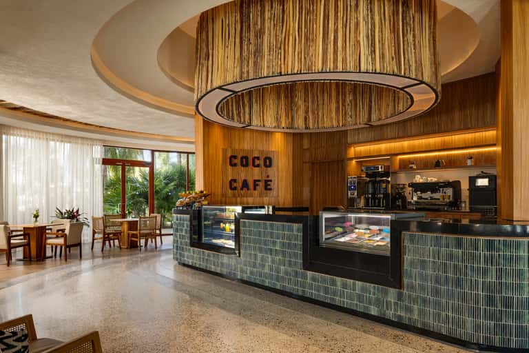 Coco Cafe interior with rounded wooden ceiling details, curved counter, and warm ambient lighting