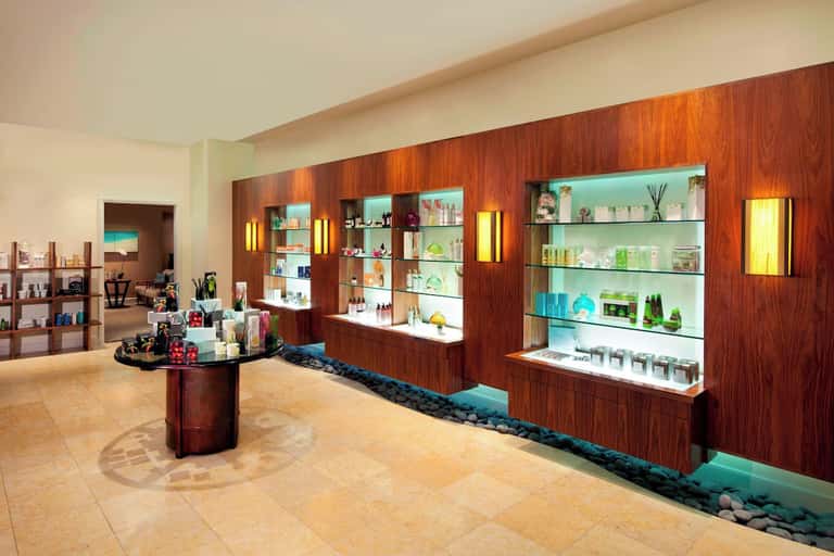 Luxury spa retail display with illuminated shelving, wood accents, and decorative centerpiece