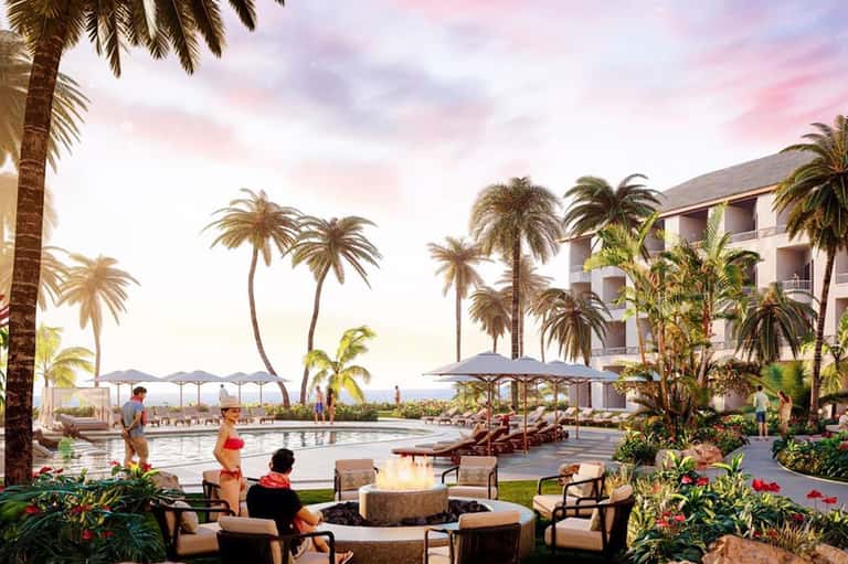 Luxury resort courtyard with fire pit, lounge seating, pool, and palm trees at sunset