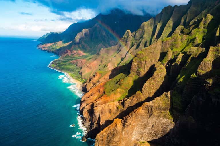 Dramatic coastal cliffs with lush green vegetation overlooking turquoise ocean waters