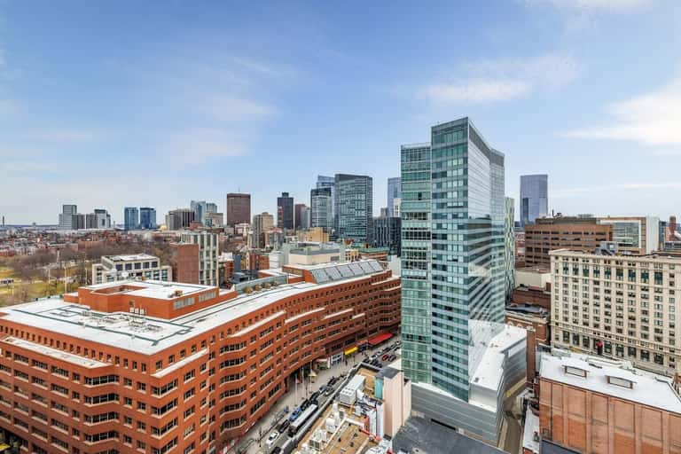 Urban skyline view showing mix of modern high-rises and historic brick buildings in downtown area