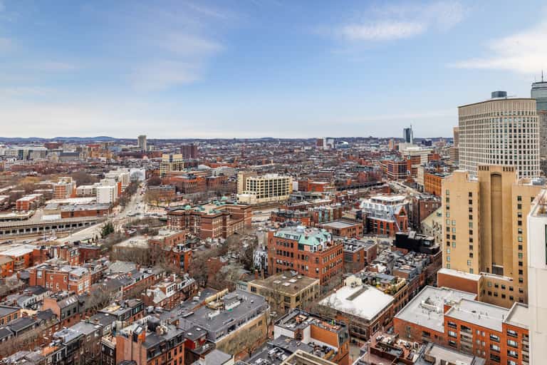 Wide cityscape view of historic brick buildings and urban skyline with clear blue sky