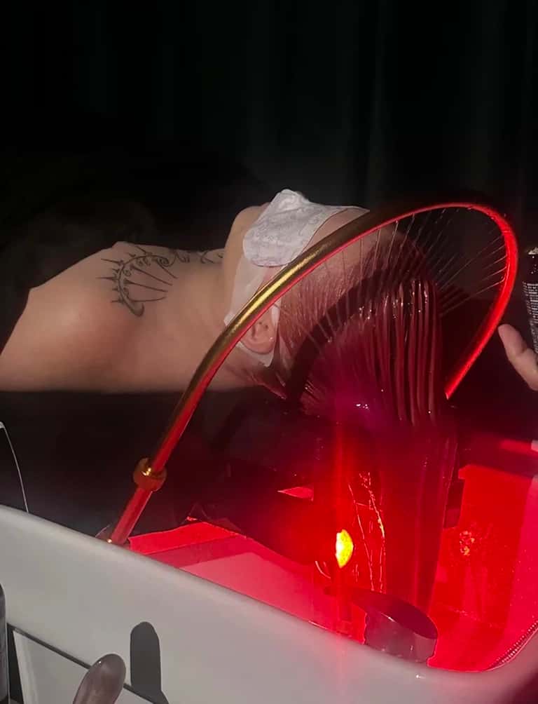 Red neon light tanning bed with luminescent tube edges and internal light effects during nighttime use