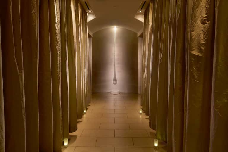 Modern spa corridor with gold curtains and minimalist pendant lighting