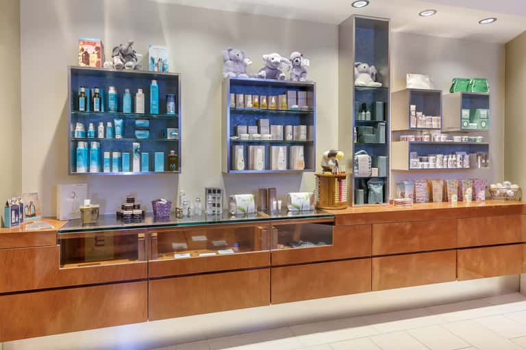 Spa retail counter with illuminated shelves displaying skincare products and amenities