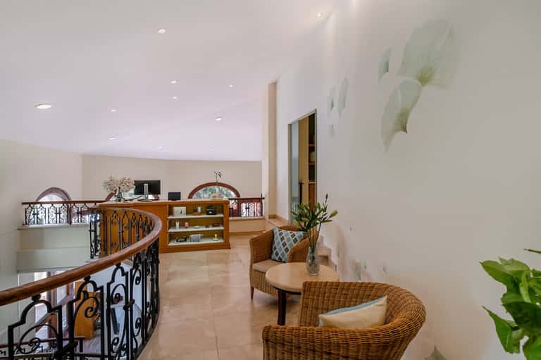 Resort lobby with spiral staircase, wicker seating, and curved railings