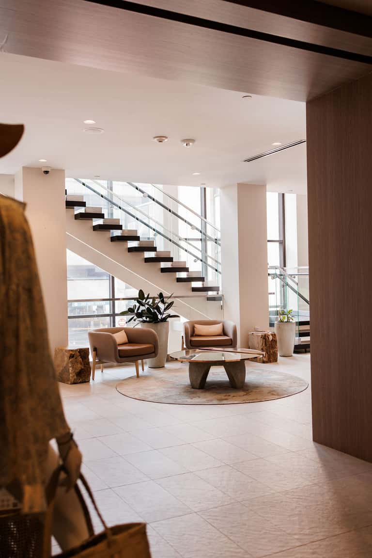 Modern resort lobby featuring floating staircase, wood accents, and natural light