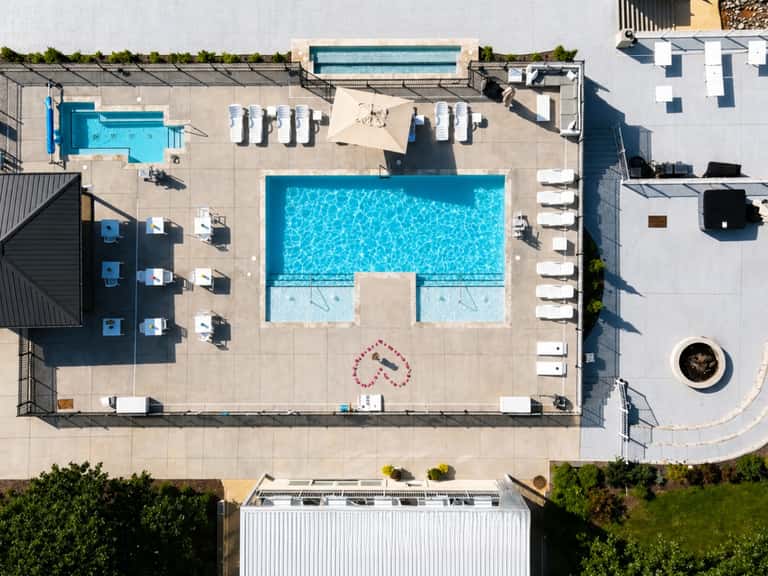 Overhead view of resort pool complex with lounge chairs and surrounding buildings
