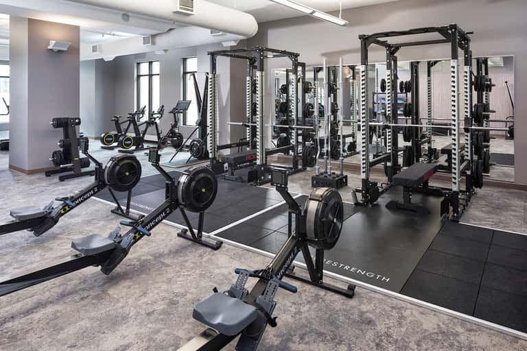 State-of-the-art fitness center with cardio bikes, cable machines, strength training equipment, and mirrors
