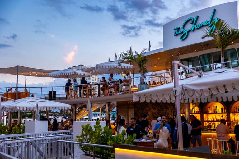 Elevated beachfront dining venue 'The Shack' with evening lighting and ocean views