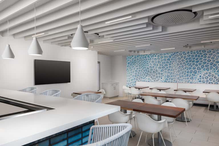 Contemporary conference room with white pendant lights, wooden tables, and blue patterned wall art