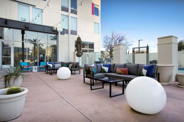 Rooftop terrace with contemporary seating, decorative white spheres, potted plants, and city views