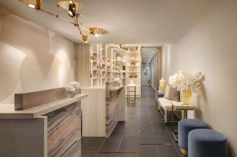 Spa corridor featuring reception desk, white built-in shelving, orchid arrangements, and modern fixtures