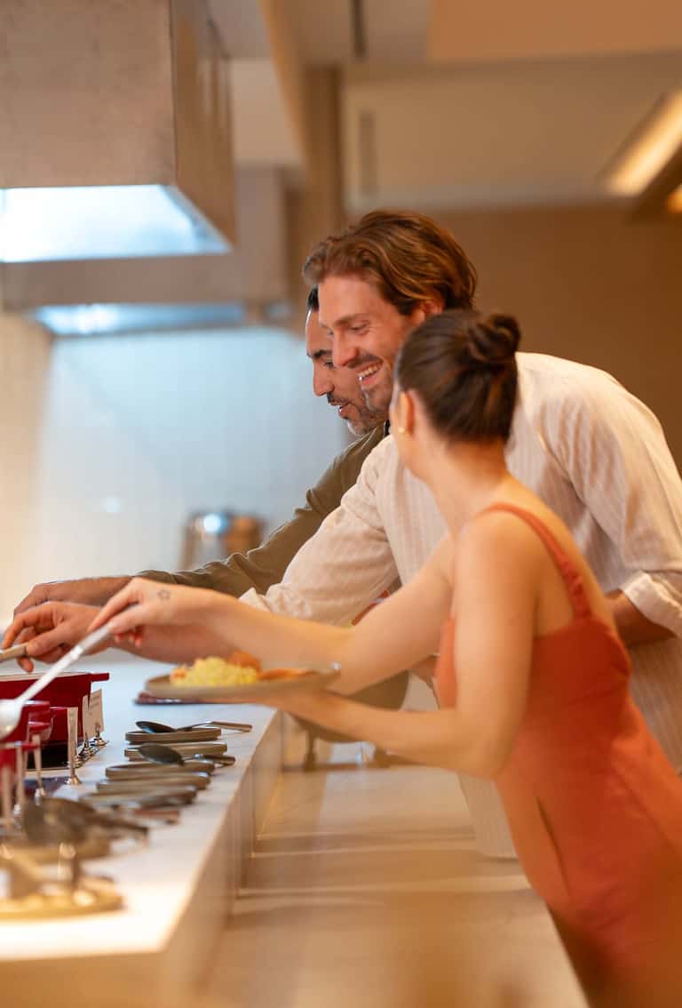 Man and woman examining jewelry at a luxury retail display counter in an upscale hotel setting