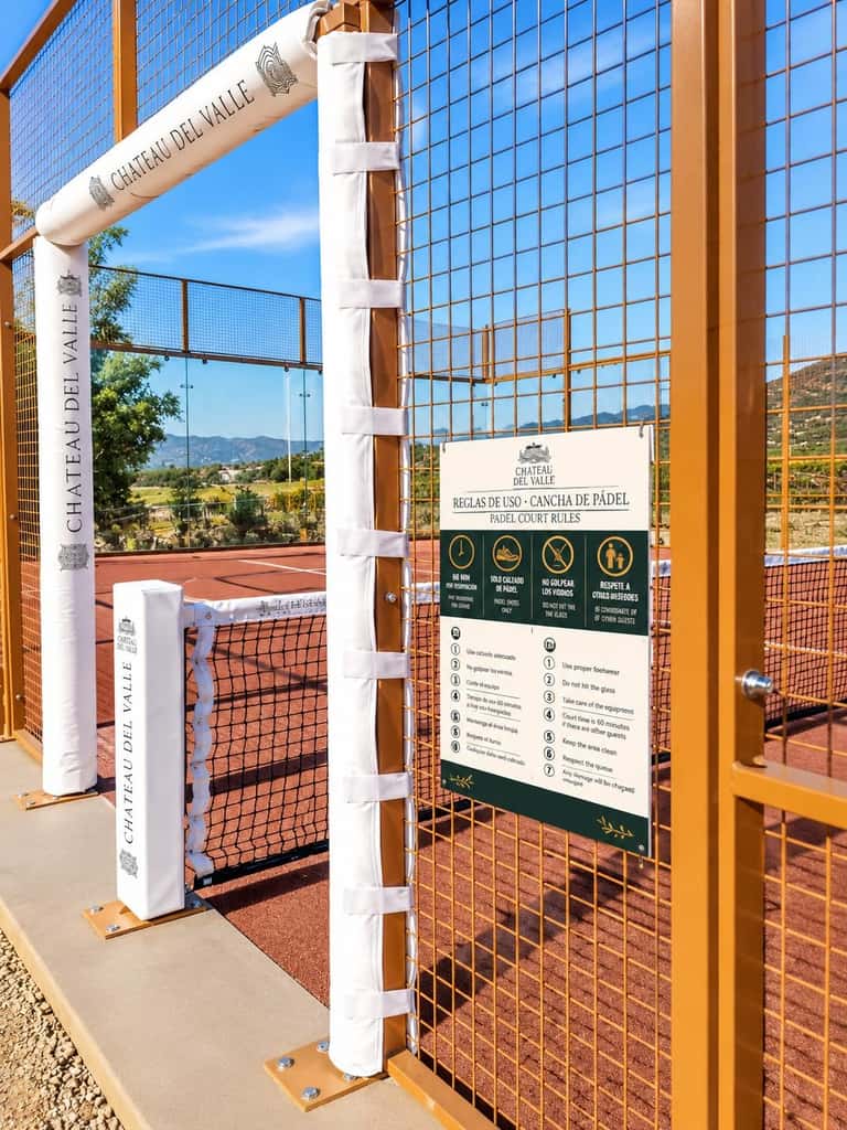 Padel court entrance at Chateau del Valle with rules sign and mountain backdrop