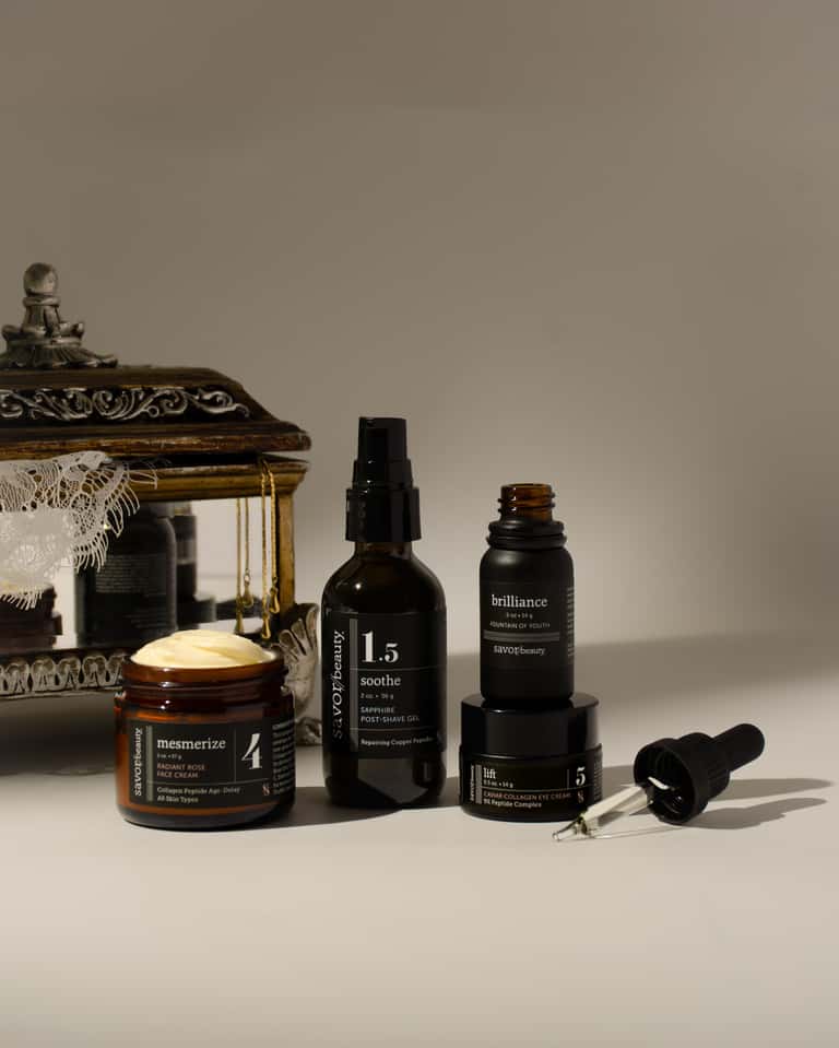 Luxury skincare product collection displayed with ornamental décor and dropper bottle