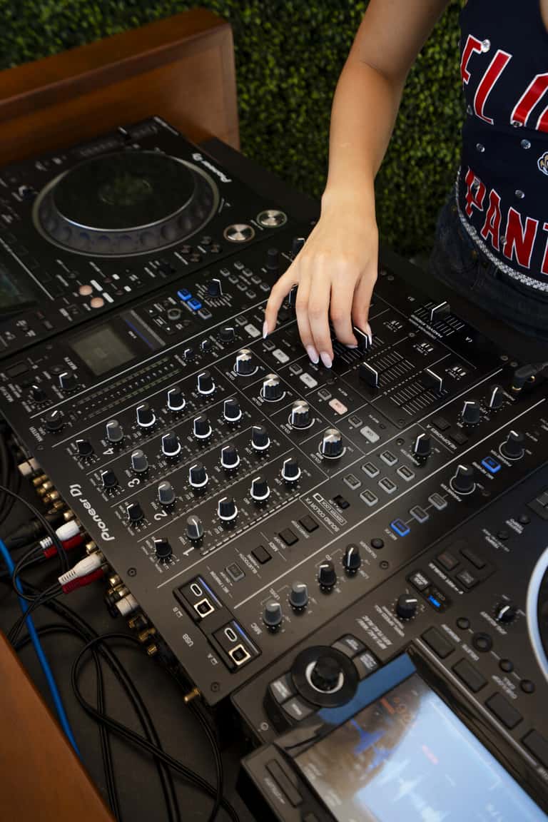 DJ operating audio mixing equipment at an indoor event or celebration