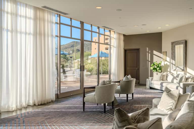 Luxury living room with floor-to-ceiling windows, sheer curtains, and mountain views