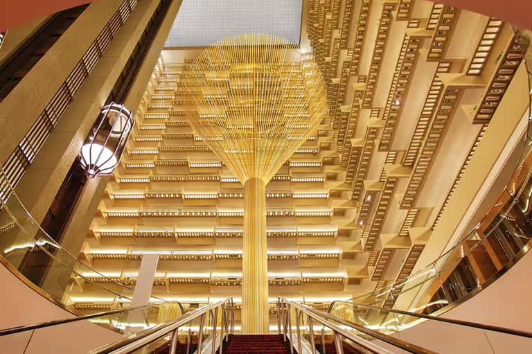 Grand hotel atrium with ornate golden ceiling and symmetrical architectural design
