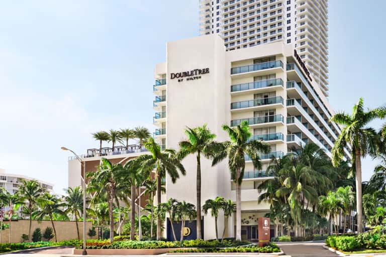 DoubleTree by Hilton beachfront hotel with palm trees and modern architecture