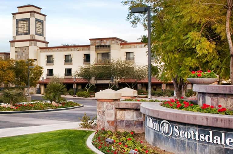 Hilton Scottsdale resort entrance with white building, bell tower, and colorful flower gardens