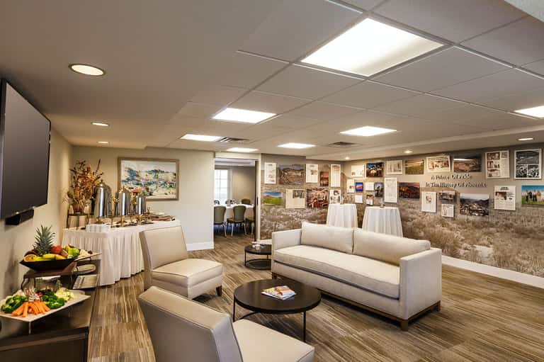 Modern hotel lounge with cream sofa, casual seating, and historical photo gallery wall