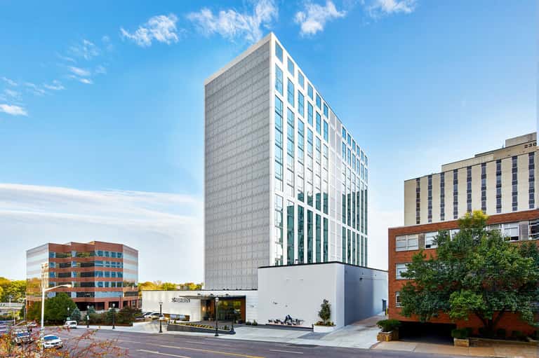 Modern multi-story hotel building with white and gray facade in urban setting