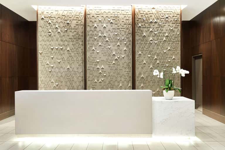 Modern hotel lobby with white marble reception desk and textured wall panels