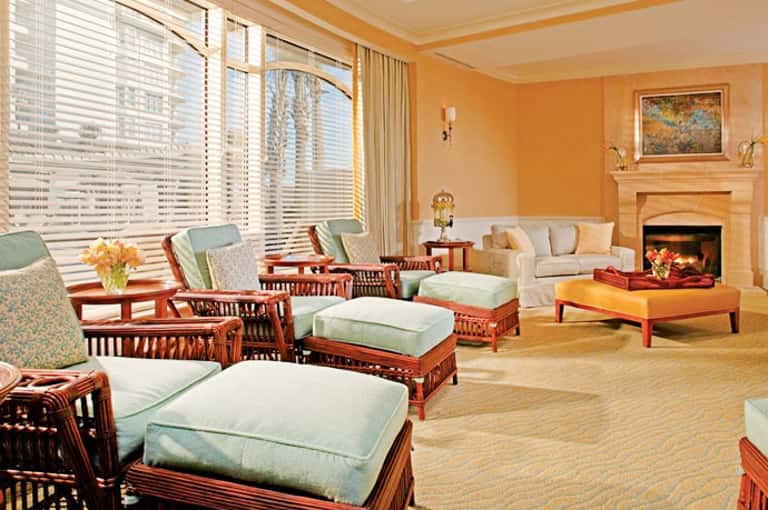 Elegant living room with orange walls, fireplace, wooden furniture, and large windows overlooking city skyline