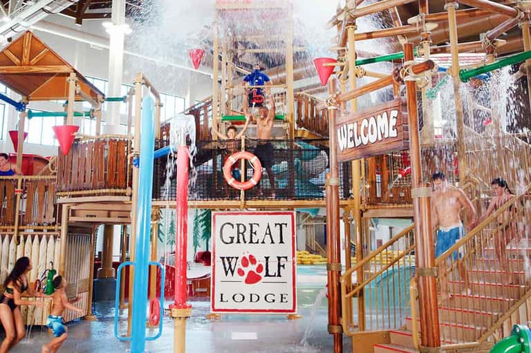 Indoor water park at Great Wolf Lodge with wooden structures, water slides, and splash areas