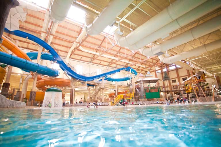 Indoor water park with blue water slides and recreational pools