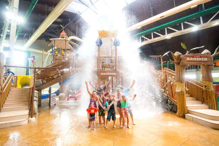 Children enjoying water play at indoor water park with Fort Mackenzie themed structures