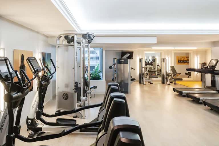 Modern hotel fitness center with elliptical machines, treadmills, and weight equipment