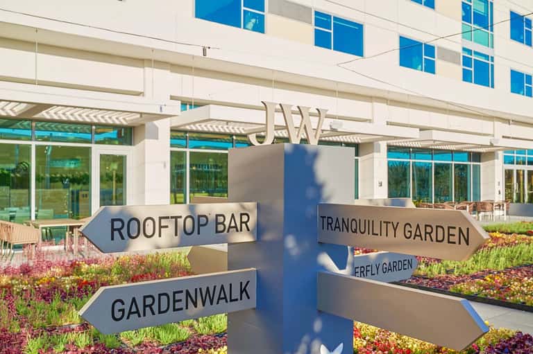 Directional signage pointing to rooftop bar, tranquility garden, and garden walk areas