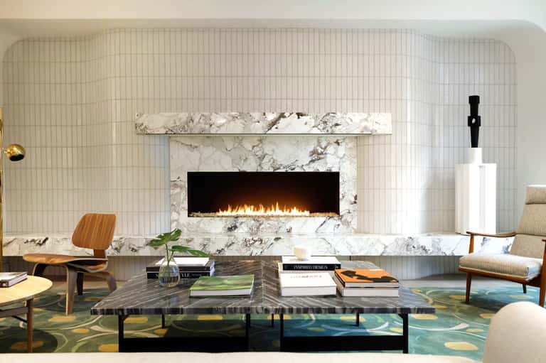Modern living room with marble fireplace, mid-century furniture, and geometric area rug