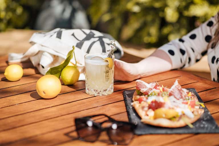 Outdoor dining table with cocktail, fresh fruit, appetizer, and polka dot clothing