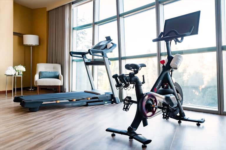 Modern hotel fitness center with treadmill, stationary bike, and floor-to-ceiling windows