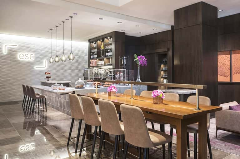 Modern lounge bar with dark wood cabinetry, pendant lights, and elegant seating at counter