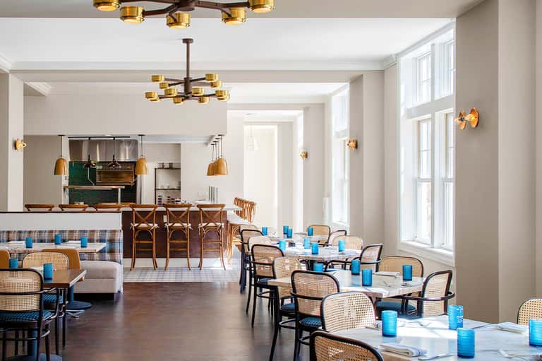Elegant dining room with rattan chairs, pendant lights, and a central bar area