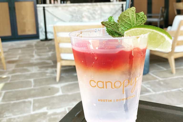 Red tropical cocktail with lime and mint at Canopy hotel in Austin Downtown