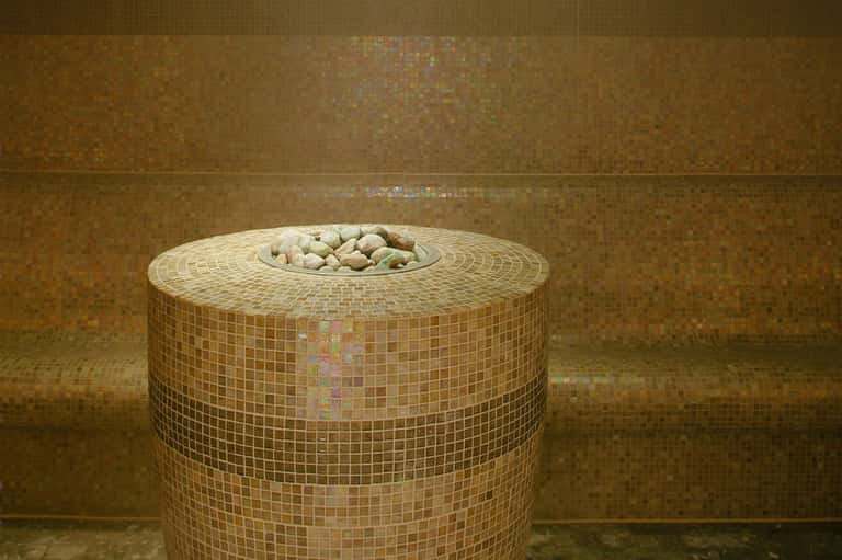 Circular mosaic tile decorative feature with stones in spa or wellness center