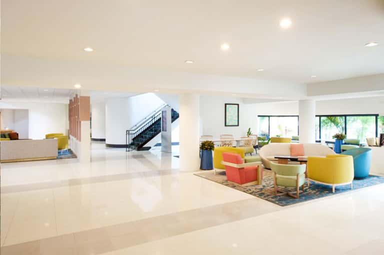 Bright, spacious hotel lobby with colorful mid-century modern furniture and high ceilings