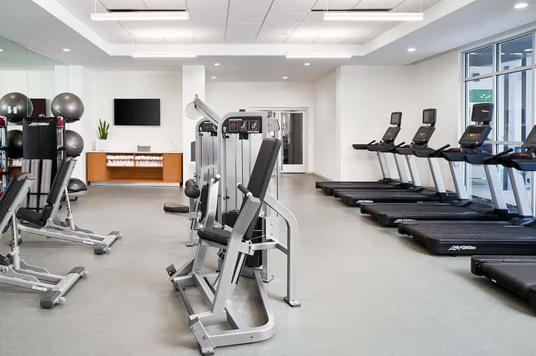 State-of-the-art fitness center with treadmills, exercise equipment, and large windows
