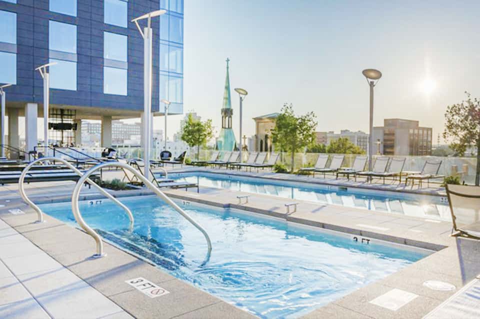 Spa and hot tub area on rooftop with city skyline and church steeple in background