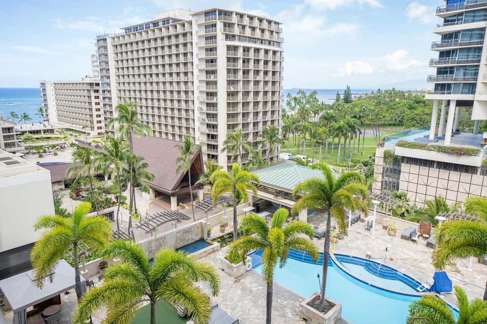 Aerial view of beachfront resort complex with multiple high-rise buildings and pool area