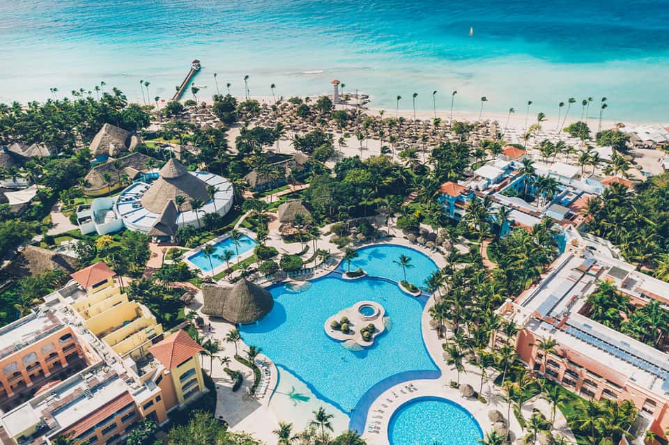 Aerial view of sprawling beachfront resort with multiple pools, water slides, and sandy beach