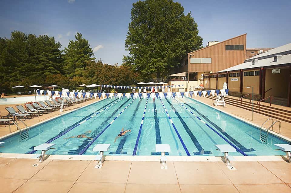 Olympic-style lap pool with lane dividers and lounge chairs in outdoor facility