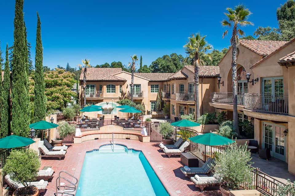 Luxury resort courtyard with turquoise pools, terra cotta architecture, and Mediterranean landscaping